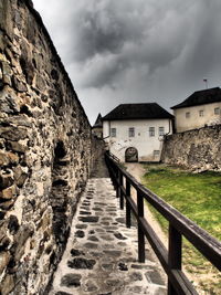 Houses by retaining wall against sky