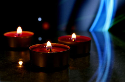 Close-up of lit candles on table