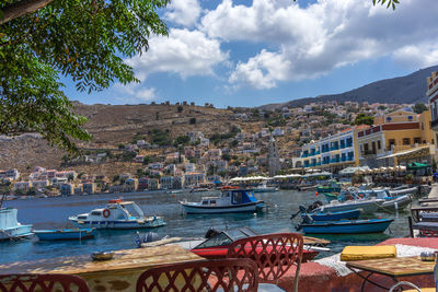 Boats moored in city against sky