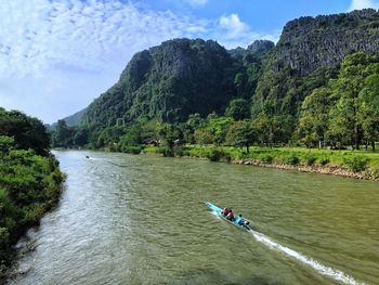 Scenic view of river amidst trees against sky