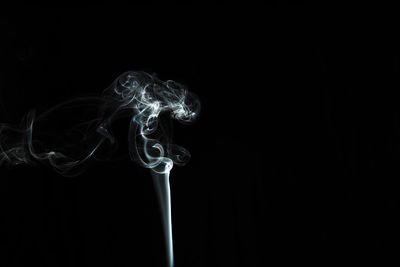 Close-up of smoke emitting from black background
