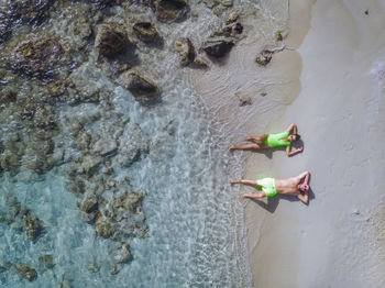 Aerial view of couple lying down at beach