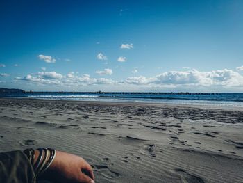 Midsection of man on beach against sky