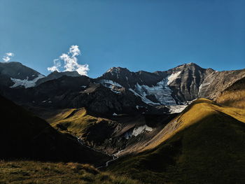 Scenic view of snowcapped mountains against blue sky