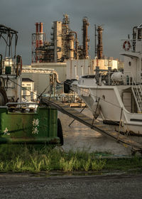 View of factory at harbor against sky