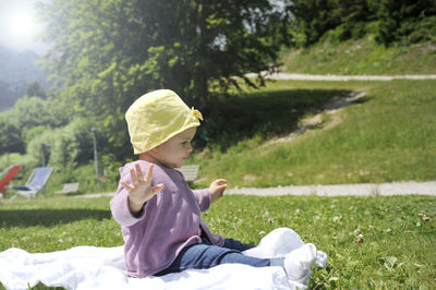 Side view of a boy sitting on field