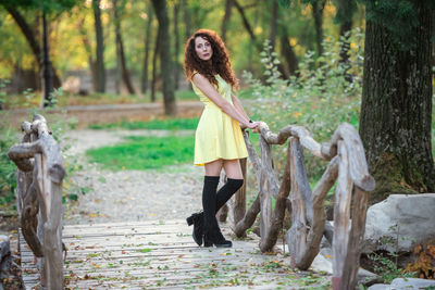 Woman standing by tree in forest