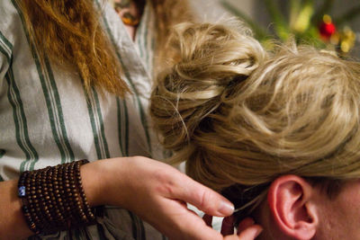 Close-up portrait of two women preparing hairstyle