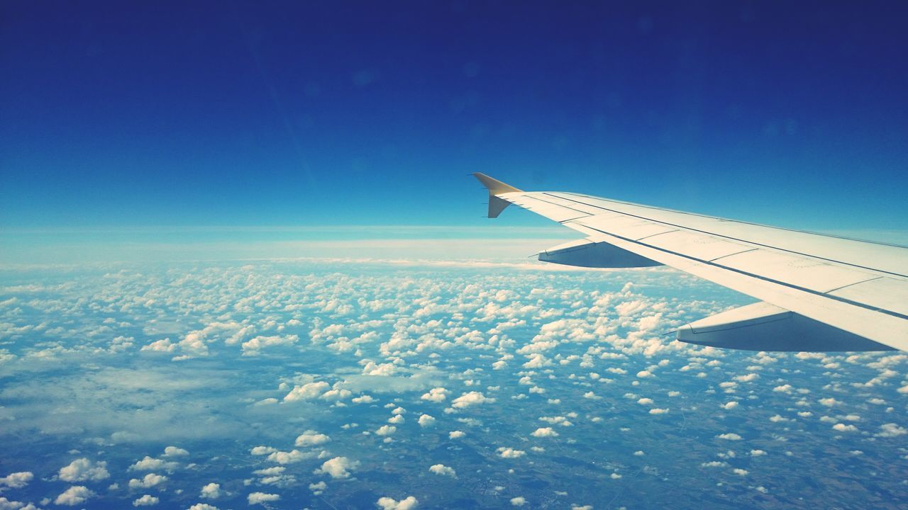 airplane, aircraft wing, air vehicle, flying, blue, transportation, aerial view, mode of transport, part of, cropped, sky, travel, mid-air, landscape, journey, on the move, scenics, beauty in nature, nature, airplane wing