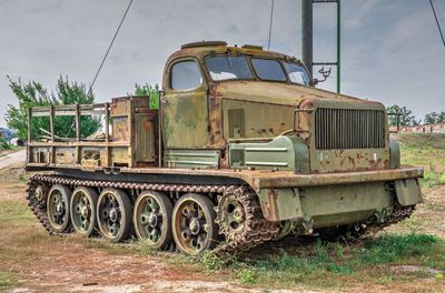 Abandoned truck on field against sky