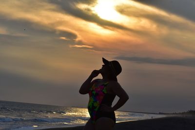 Man on beach against sky during sunset