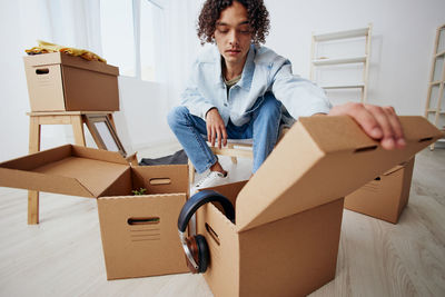 Man opening cardboard boxes at home