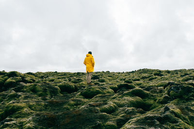 Full length of man standing on rock against sky