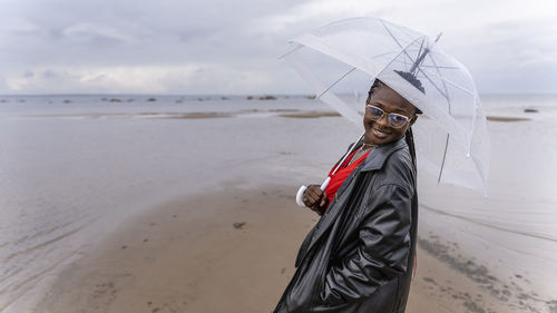 Africa woman with umbrella when it rains at the coast during the month of september