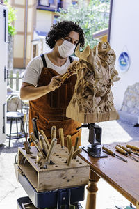 Sculptress with mask carving wooden figure