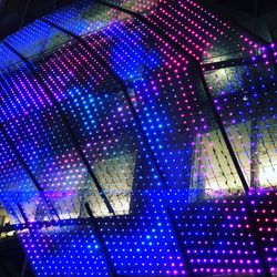 Low angle view of illuminated lights on glass ceiling