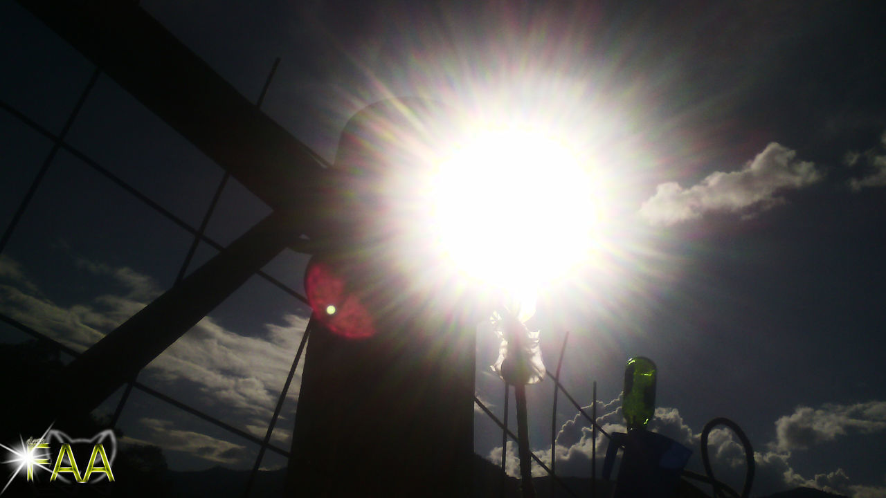 LOW ANGLE VIEW OF SUN SHINING THROUGH CLOUDS