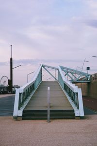 Empty pier over sea against sky