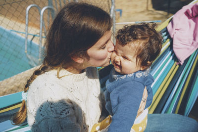 Close-up of mother and daughter sitting on hammock