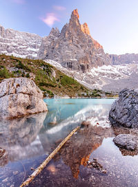 Scenic view of lake by mountains against sky