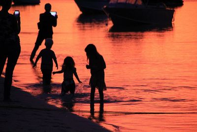 People in water at sunset