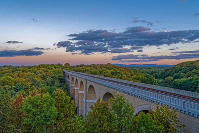 Arch bridge against sky during sunset