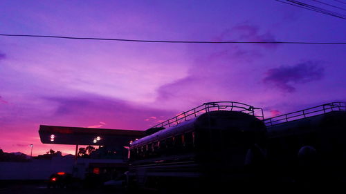 Illuminated road against sky at sunset