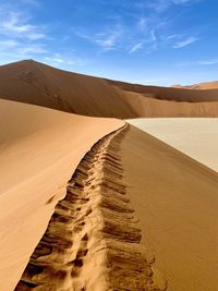 Sand dunes in desert against sky
