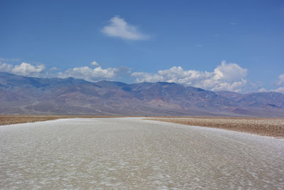 Scenic view of arid landscape and salt against sky and desert