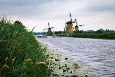 Traditional windmill on land against sky