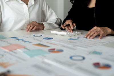 Midsection of business colleagues working on table