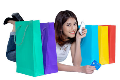 Portrait of happy young woman against gray background