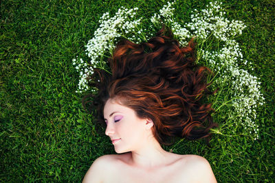 Directly above shot of young woman with long hair lying down on grass