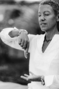 Female crystal healing therapist meditating, manifesting abundance with white selenite crystal.