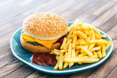 Close-up of burger and french fries in plate on table