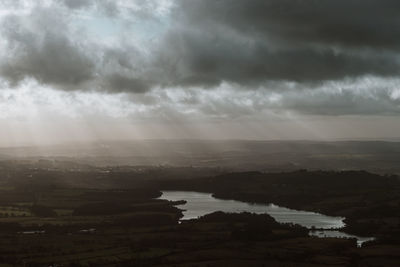 Scenic view of river against cloudy sky