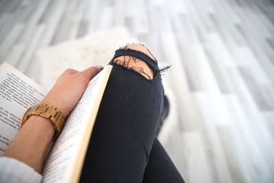 Low section of woman reading book