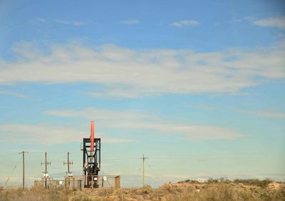 Lifeguard tower on field against sky