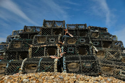 Lobster pots stacked on the beach at the costal town of eastbourne, east sussex. low angle view.