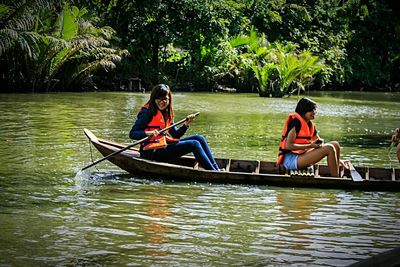 Rear view of people sitting in river