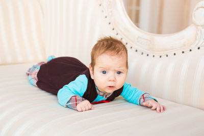 Portrait of cute baby lying on sofa