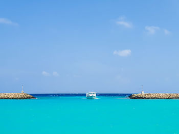 Sailboats in sea against blue sky