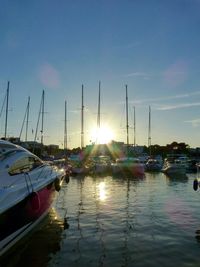 Sailboats in sea at sunset