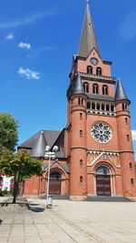 Clock tower amidst buildings in city against sky