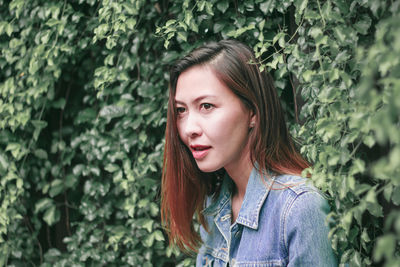 Beautiful woman standing against plants in park