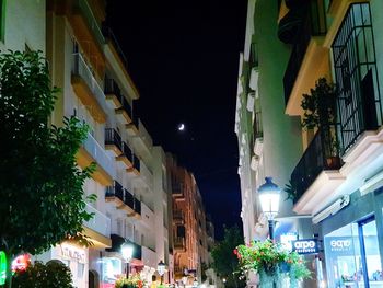 Low angle view of illuminated buildings against sky at night