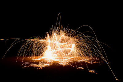 Firework display against sky at night