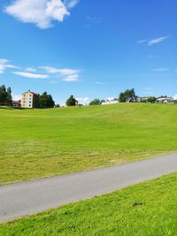 View of grassy field against cloudy sky