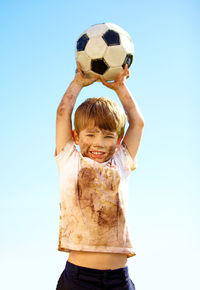 Rear view of woman holding soccer ball against white background