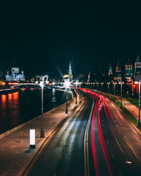 Light trails on road against sky at night